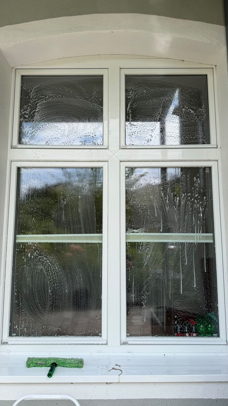 Fenster vor der Reinigung: Glas mit Seifenlauge und Schlieren