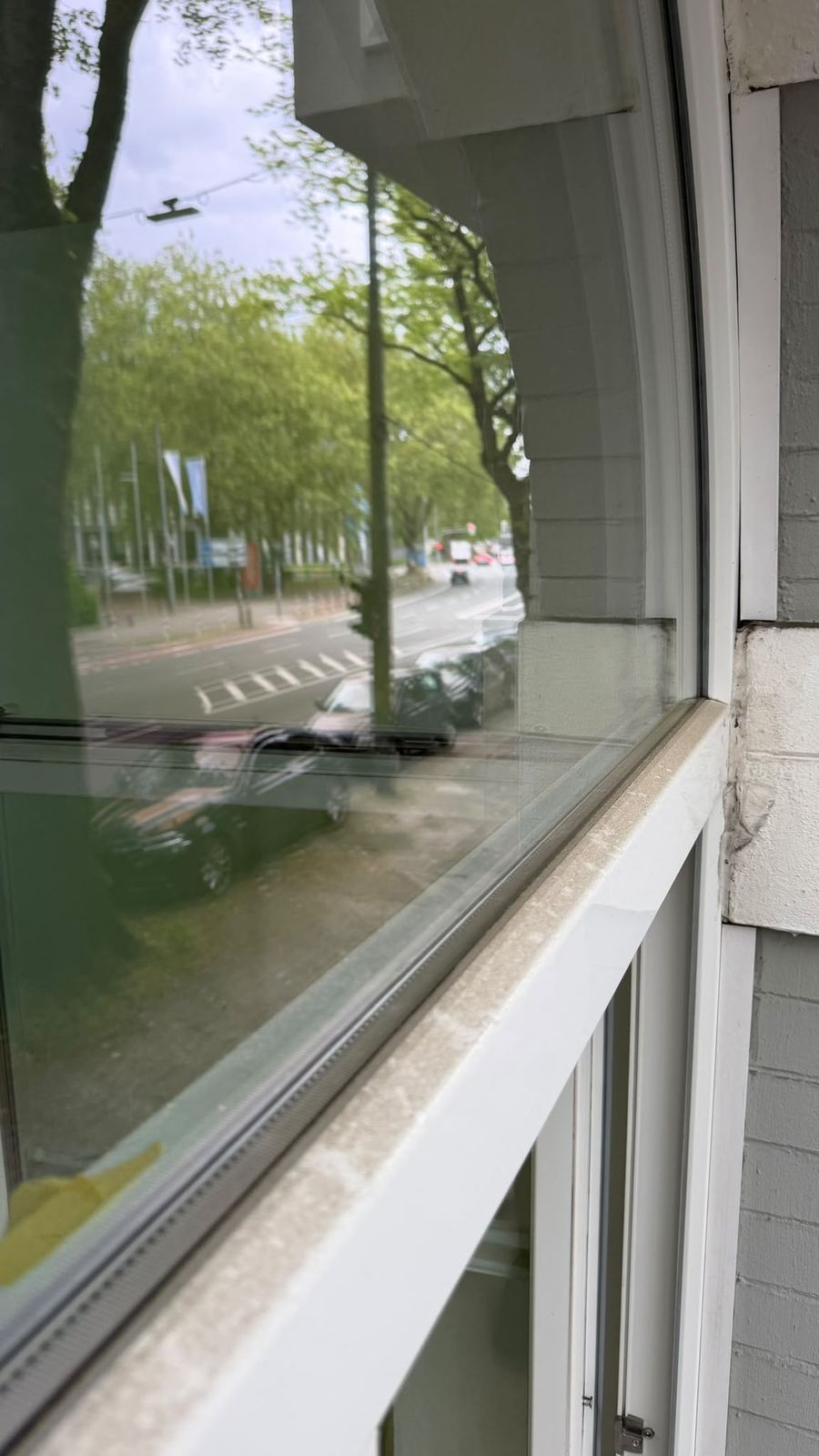 Fensterbank und Glas vor der Reinigung: Staub und Schmutz am Rand